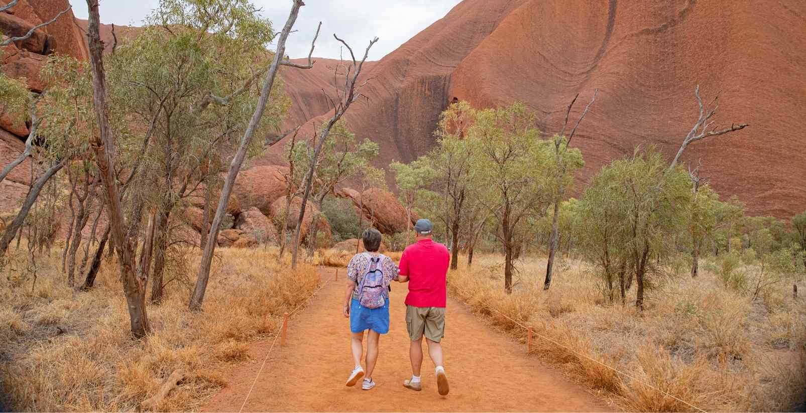 people walking around base of uluru