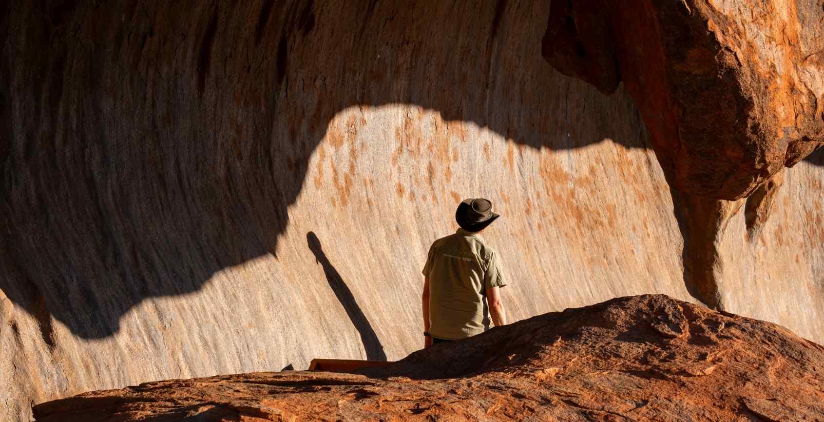 man standing near rock formations