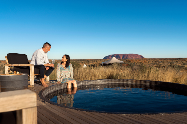 Couple sitting by edge of plunge pool near Uluru