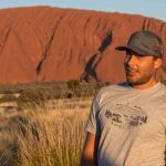 Man standing in front of uluru
