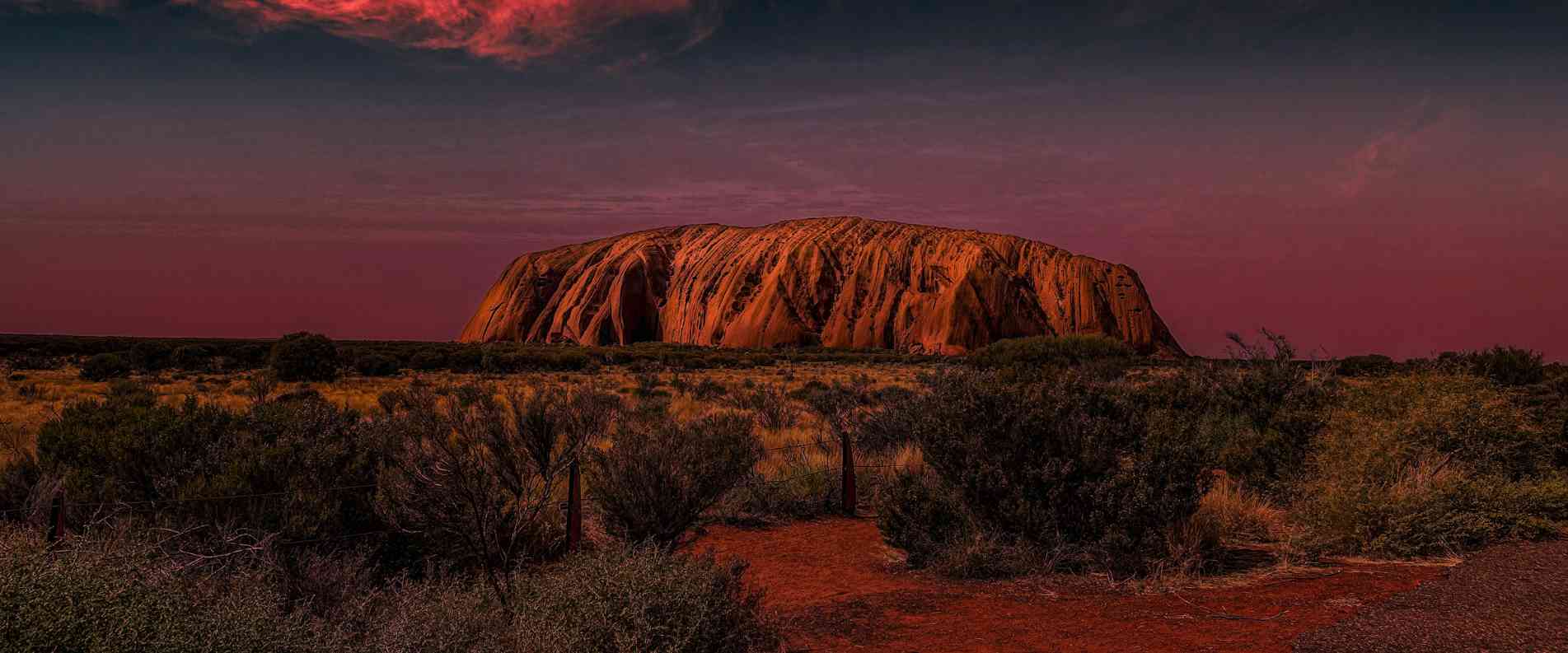 Uluru at dusk with dark skies