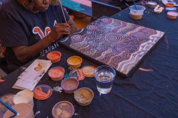 One of the artists painting for the Gallery of Central Australia